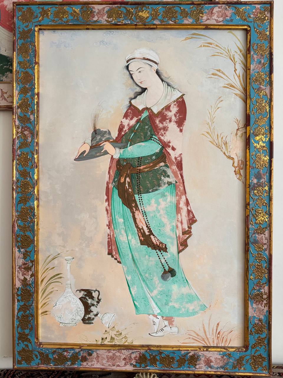 Framed Persian miniature of a standing woman holding a tray