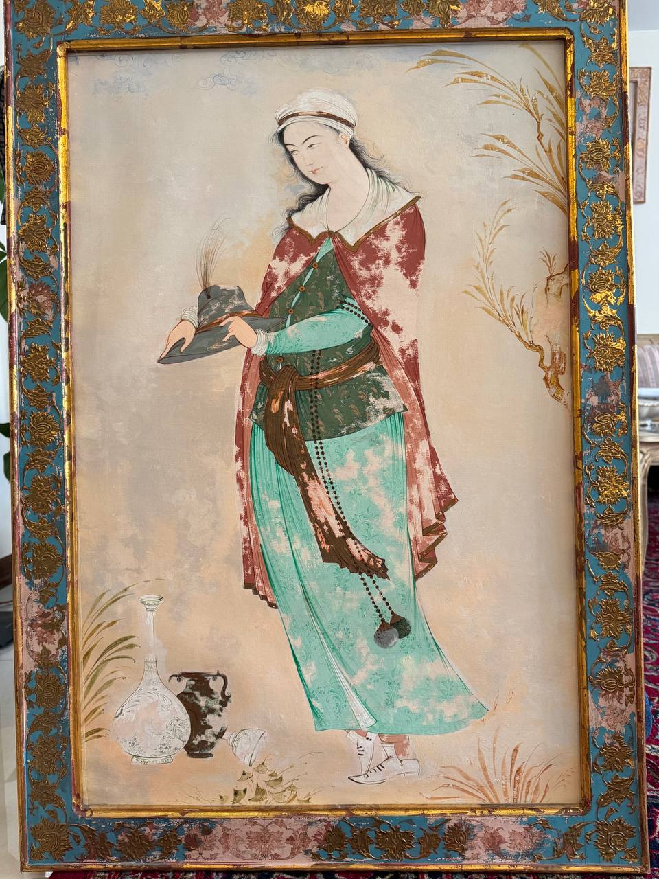 Persian miniature of a standing woman in an ornate blue and gold frame