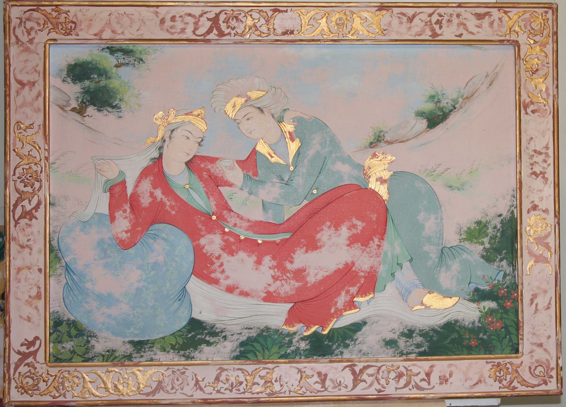Persian miniature of a man and woman reclining in a landscape